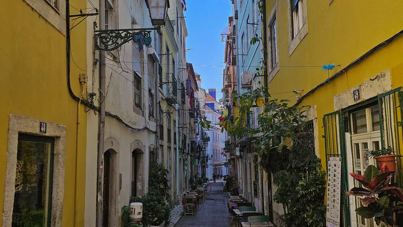 Narrow Alfama streets in Lisbon lined with outdoor café tables