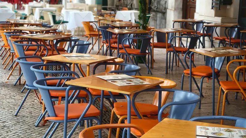 Outdoor café chairs and tables on a cobblestone street in Lisbon